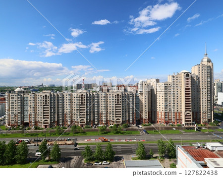The urban skyline features striking buildings against a blue sky, with lush green spaces The urban skyline features striking buildings against a blue sky, with lush green spaces 127822438