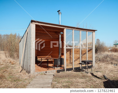 A Modern Wooden Cabin Featuring Expansive Glass Walls Nestled in a Beautiful Open Field Space A Modern Wooden Cabin Featuring Expansive Glass Walls Nestled in a Beautiful Open Field Space 127822461