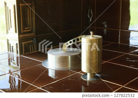 An Elegant Brass Fixture Displayed Beautifully on a Brown Tiled Surface in a Contemporary Setting An Elegant Brass Fixture Displayed Beautifully on a Brown Tiled Surface in a Contemporary Setting 127822532
