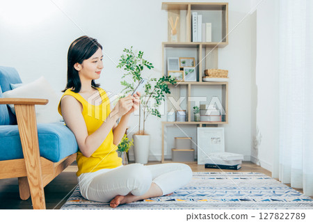 A woman looking at her smartphone in the living room A woman looking at her smartphone in the living room 127822789