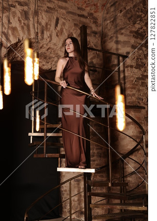 An Elegant Woman Gracefully Posing in a Beautiful Vintage Staircase Setting, Captured Artistically 127822851