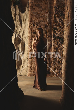 A Contemplative Figure Illuminated by Dramatic Lighting Surrounded by Ancient Walls A Contemplative Figure Illuminated by Dramatic Lighting Surrounded by Ancient Walls 127823088