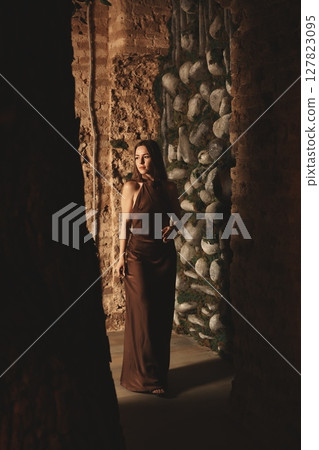 A Mysterious Woman Elegantly Dressed in Earthy Tones and Hues Captivating the Eye A Mysterious Woman Elegantly Dressed in Earthy Tones and Hues Captivating the Eye 127823095