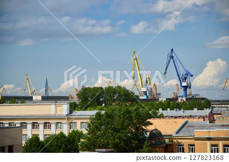 An industrial scene with cranes against a blue sky, highlighting modern construction An industrial scene with cranes against a blue sky, highlighting modern construction 127823168
