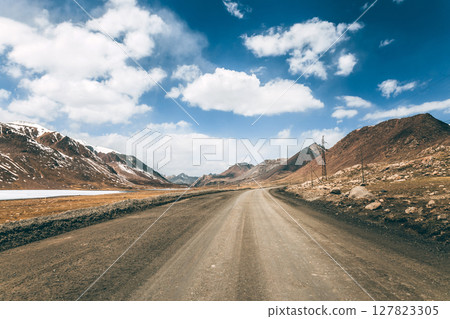 Ideal gravel road in the highlands, mountainous natural landscape. 127823305