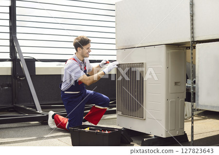 Repairman Inspecting And Fixing Hvac Air Conditioner On Roof Repairman Inspecting And Fixing Hvac Air Conditioner On Roof 127823643