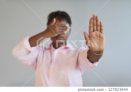 African American woman protecting from problems by covering her eyes and showing stop gesture African American woman protecting from problems by covering her eyes and showing stop gesture 127823644