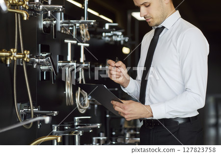 Consultant Conducts Inventory Of Bathroom And Kitchen Faucets Consultant Conducts Inventory Of Bathroom And Kitchen Faucets 127823758
