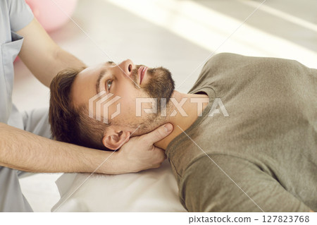 Therapist Or Masseur Stretching Patient's Neck During Rehabilitation 127823768