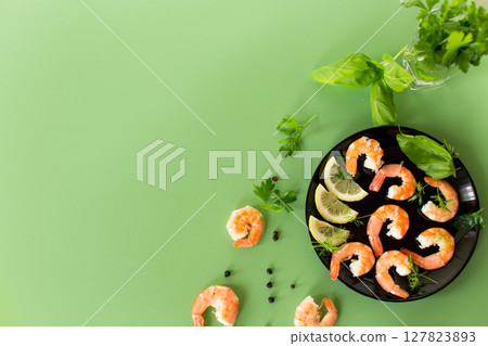 Ready to eat red shrimps with lemon isolated on green background 127823893