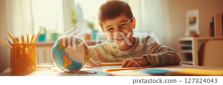Happy child engaging with a globe and colorful pencils, immersing in geography lessons while enjoying the cheerful back to school vibe in a sunlit classroom 127824043