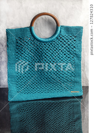 Knitting a product from a cord with a crochet hook. Step-by-step instructions 127824310