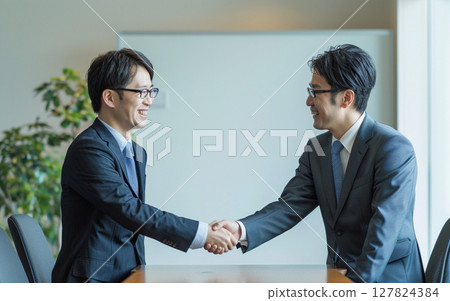 Men in suits shaking hands in a business deal 127824384