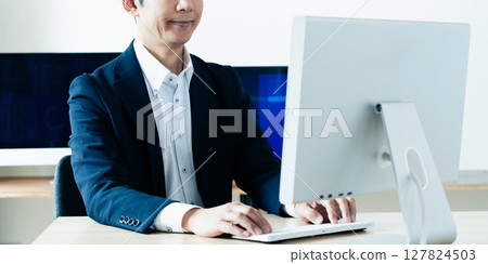 Middle-aged man facing a computer 127824503