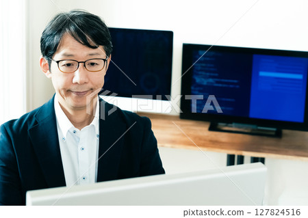 Middle-aged man facing a computer Middle-aged man facing a computer 127824516