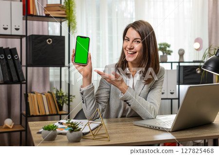 Business woman holding smartphone with green screen chroma key mock up recommend good application 127825468