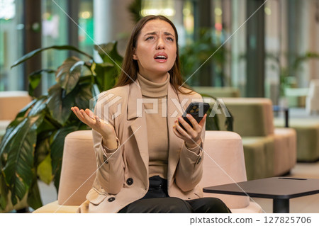 Caucasian business woman use smartphone surprised by bad news, fortune loss, fail, lottery results 127825706