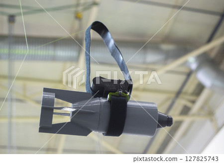 Hanging bomb. Bomb model for drone. Model of bomb printed on 3D printer from melted plastic. Body of bomb with tail created on 3D printer. Prototype ammunition printed on 3D printer Innovation Hanging bomb. Bomb model for drone. Model of bomb printed on 3D printer from melted plastic. Body of bomb with tail created on 3D printer. Prototype ammunition printed on 3D printer Innovation 127825743
