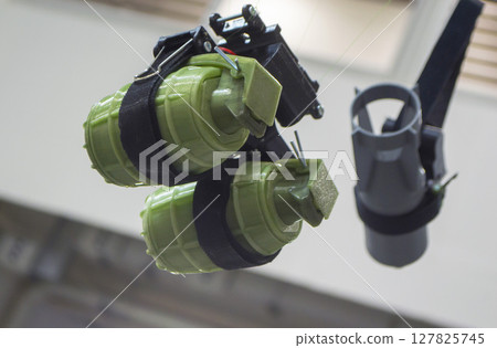 Hanging grenade. Grenade printed on 3D printer from melted plastic. Plastic grenade created on 3D printer. Prototype of ammunition printed on 3D printer. Innovation 3d printing. Innovation technology Hanging grenade. Grenade printed on 3D printer from melted plastic. Plastic grenade created on 3D printer. Prototype of ammunition printed on 3D printer. Innovation 3d printing. Innovation technology 127825745