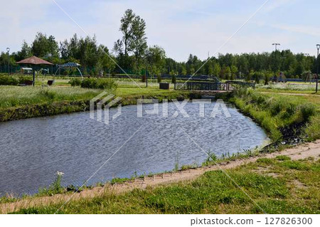 A Serene and Beautiful Park Landscape Featuring a Tranquil Water Body and Surroundings A Serene and Beautiful Park Landscape Featuring a Tranquil Water Body and Surroundings 127826300