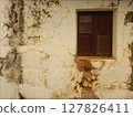 Old wooden window in an old white facade 127826411