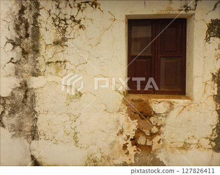 Old wooden window in an old white facade 127826411