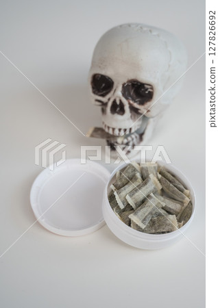 Skull Chewing Tobacco on a White Table. Skull Chewing Tobacco on a White Table. 127826692