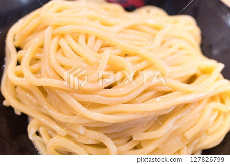 Thick tsukemen noodles served in a black bowl 127826799