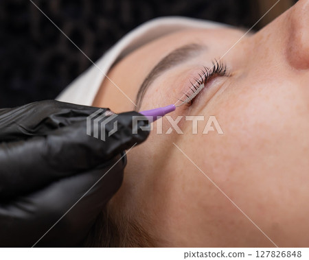 The process of professional eyelash lamination in a salon.  127826848