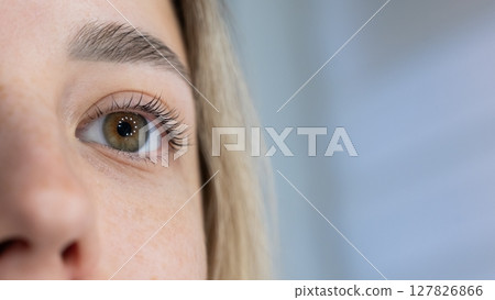 Close-up of a woman's eye after eyelash lamination procedure.  127826866
