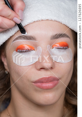 The process of professional lamination and dyeing of eyelashes and eyebrows in the salon. The process of professional lamination and dyeing of eyelashes and eyebrows in the salon. 127826895