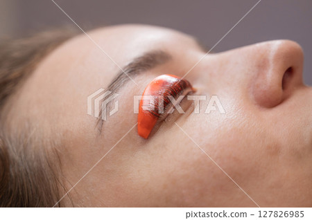 Caucasian woman undergoing eyelash lamination procedure.  127826985