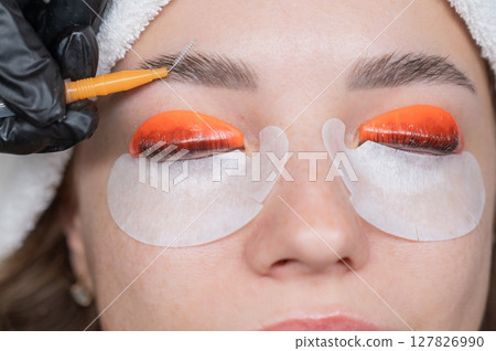 Caucasian woman undergoing eyelash lamination procedure. Caucasian woman undergoing eyelash lamination procedure. 127826990