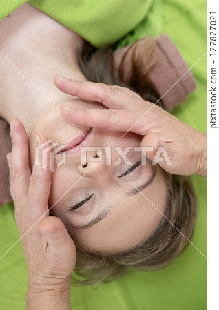 Top view of woman getting facial massage.  127827021