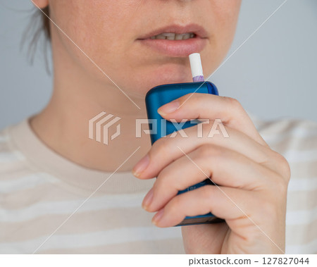 Caucasian woman smoking electronic cigarette. Tobacco heating system. 127827044