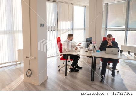 Two Caucasian men working in an office. Two Caucasian men working in an office. 127827162