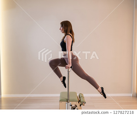 Asian woman doing pilates classic chair.  127827218