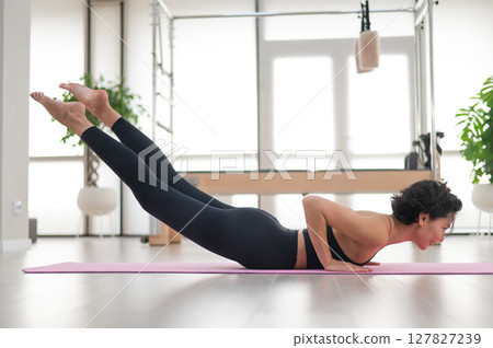 Asian woman doing yoga in studio.  127827239