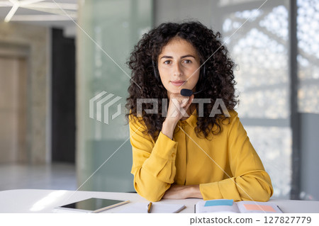 Serious woman with headset looking at camera. Web camera view, online business meeting conference. Support service worker, customer service consulting. 127827779