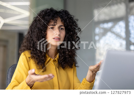 Serious and anxious woman talking to colleagues and partners sitting at desk with laptop, using video call, for remote business conference meeting. Serious and anxious woman talking to colleagues and partners sitting at desk with laptop, using video call, for remote business conference meeting. 127827973
