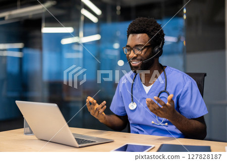 Successful experienced doctor with headset and laptop inside office at workplace working remotely. Man consulting patients, helping and supporting, video call, remote meeting conference. Successful experienced doctor with headset and laptop inside office at workplace working remotely. Man consulting patients, helping and supporting, video call, remote meeting conference. 127828187