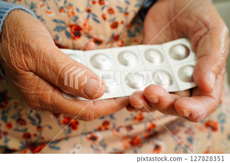 Asian elderly woman holding pill drug in hand, strong healthy medical. 127828351