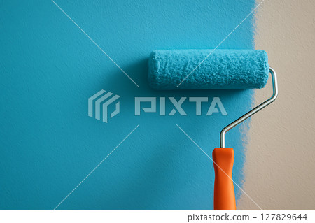 正在塗漆的藍色油漆滾筒和牆壁 正在塗漆的藍色油漆滾筒和牆壁 127829644
