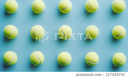 Many tennis balls are creating a repeating pattern on a light blue background, representing sport, order, and precision 127829742