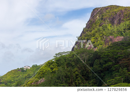 Mahe island, Seychelles. A picturesque landscape featuring a forested hill Mahe island, Seychelles. A picturesque landscape featuring a forested hill 127829856
