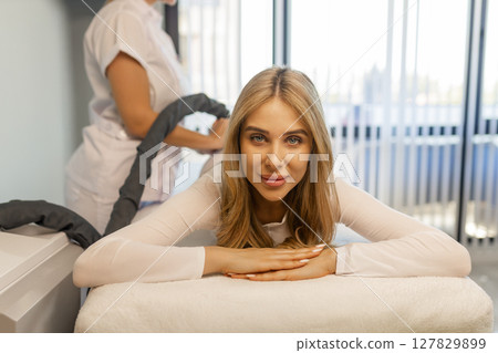 Woman in special white suit getting anti cellulite massage in a spa salon. LPG, and body contouring treatment in clinic.Reset body weight with LPG massage.  127829899
