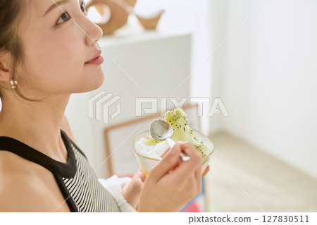 一位微笑的年輕女子吃刨冰享受夏日的生活方式 127830511