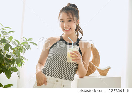Summer refreshing young woman drinking lemonade in room 127830546