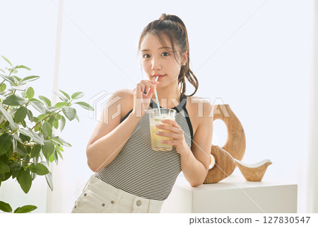 Summer refreshing young woman drinking lemonade in room 127830547