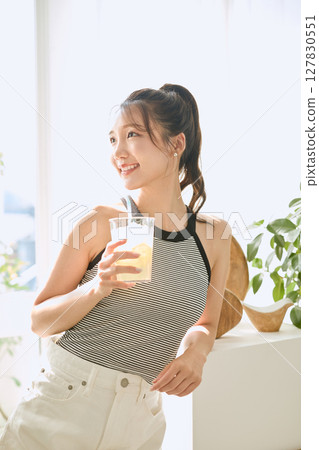 夏日清爽的年輕女子在房間裡喝檸檬水 夏日清爽的年輕女子在房間裡喝檸檬水 127830551